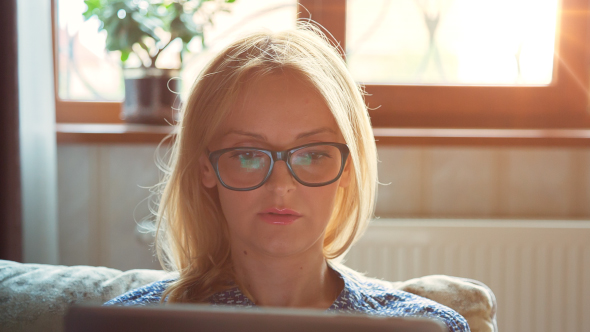 Beautiful Young Woman in Glasses Using Tablet PC for Surfing Internet 2 alt