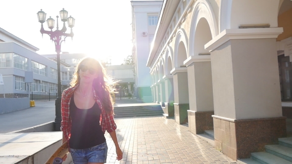 Beautiful And Fashion Young Woman With a Skateboard