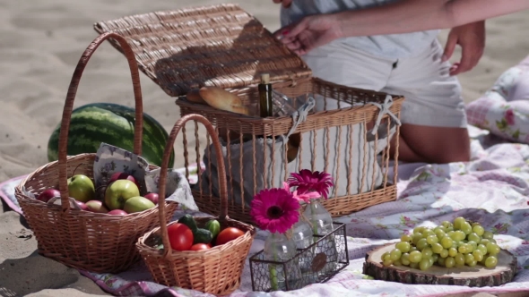 Picnic Basket On Colorful Blanket On The Beach alt