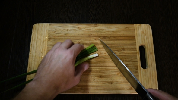 Chef Cutting Green Onions On Board alt