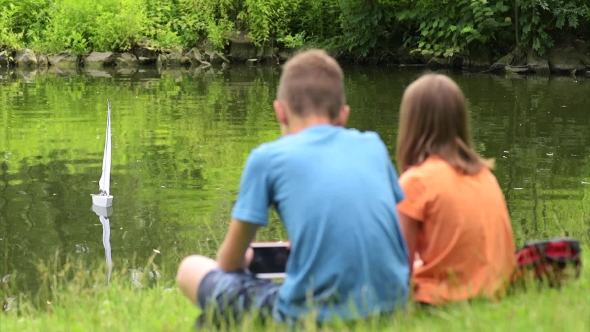 Children With Remote Controlled Boat