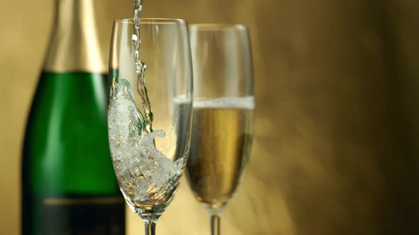 Super Slow Motion Shot of Pouring Champagne on Golden Luxury Background at 1000Fps. alt