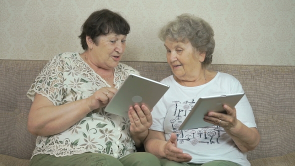 Two Elderly Women Holding The Digital Tablets