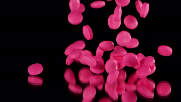 Super Slow Motion Shot of Falling Pink Pills on Black Background at 1000Fps alt