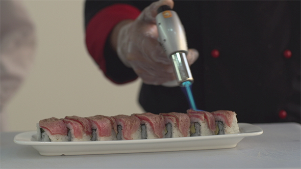 Heating Up a Sushi Roll with Salmon with a Flame Torch