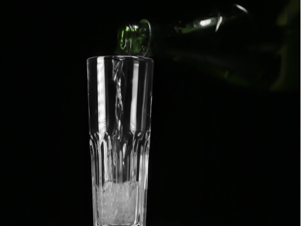 Water Pours Into Glass On The Black Background
