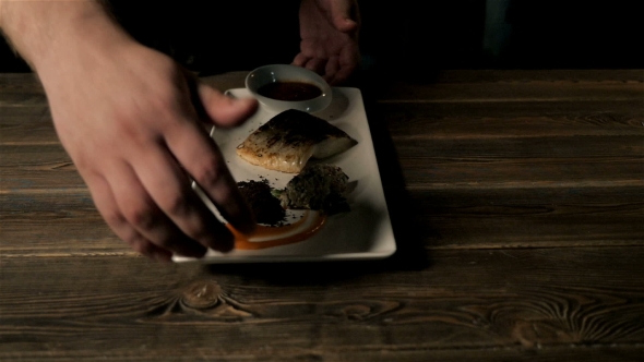 Healthy Food Concept: Chief Serving Hot Baked Fish Piece Over White Plate On Wooden Table alt