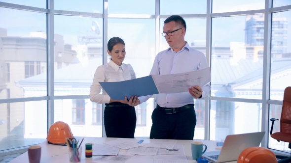 A Businessman And Businesswoman, Engineers Working In Bright Clean Office alt