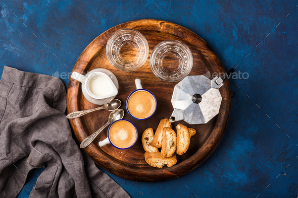 Coffee espresso, cantucci, cookies, milk and water on wooden board