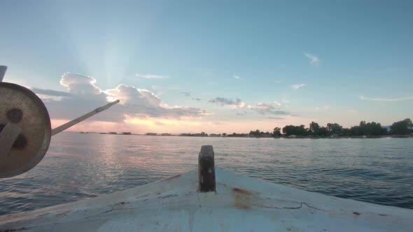 Point of view from inside of a sailing fishing boat. Sailing forward into the sunset. Calm water out alt