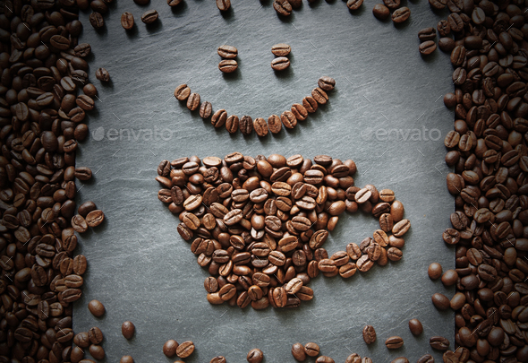 Smiley face from coffee beans at stone background