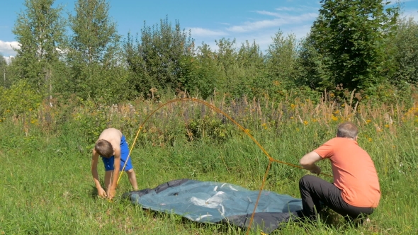 Father With Son Together Are Setting a Tourist Tent alt