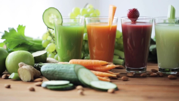 Glasses Of Juice, Vegetables And Fruits On Table alt