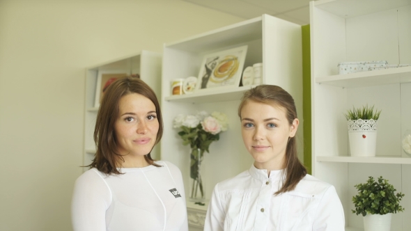 Two Girls In Medical Uniform Looking Straight And Smiling.