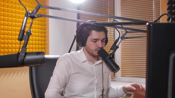 Radio and Live Broadcast Concept. Young Man with Headphones Talking on Mic, Online Radio alt