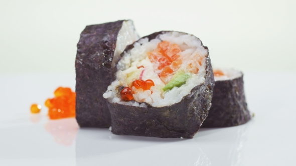 Sushi Roll With Salmon, Avocado And Caviar Rotating Over White Background