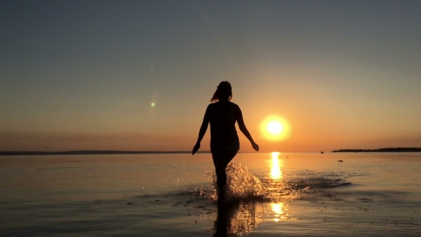 The Girl Runs On The Water At Sunset