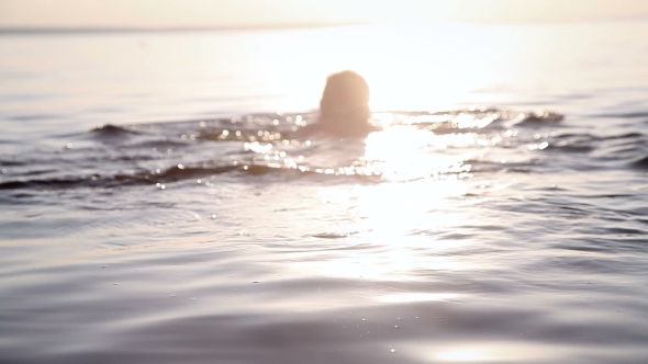 A Young Girl Floats At Sunset