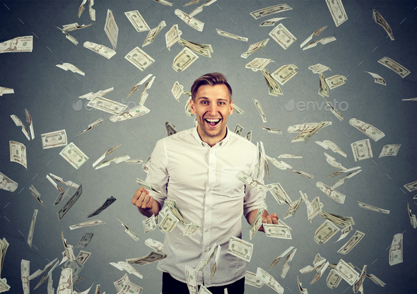 man celebrates success under money rain falling down dollar bills