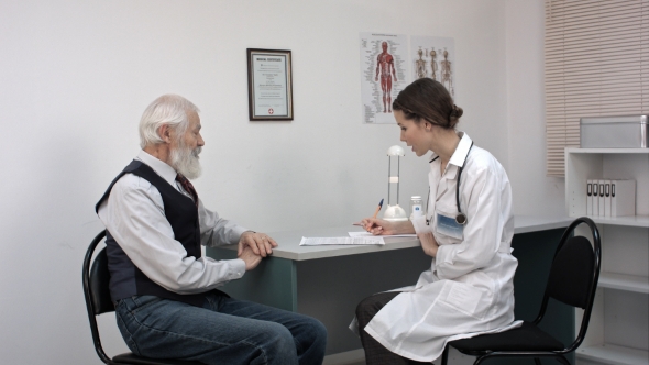 Doctor Talking To Senior Man At Her Office. alt