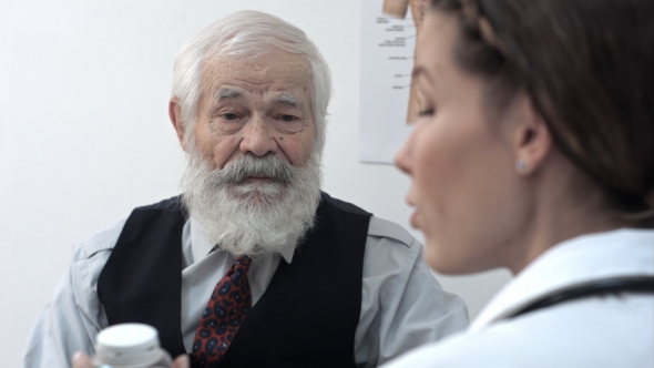 Senior Patient Looks At Doctor Who Advices Medicine, Pills. alt