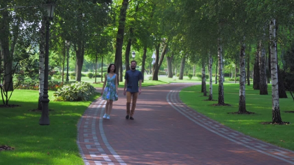 Young Couple Walking Summer Park With Birches. alt
