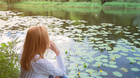 Beautiful Girl Sitting Near Lake in City Park and Dreaming 1 alt