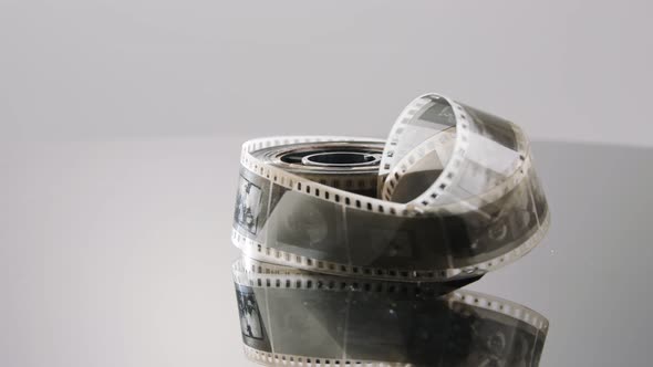 35mm film negative rotating on a reflective surface. Studio shot