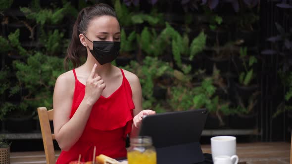 Portrait of Young Professional Business Consultant in Coronavirus Face Mask Sitting in Outdoors Cafe alt