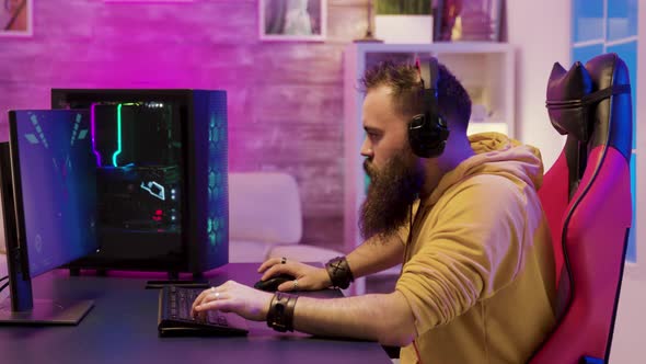 Professional Game Player Wearing Headphones in a Room with Colorful Neons alt