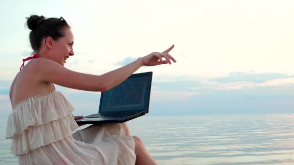 Girl With a Laptop Talking On Skype With a Loved Boyfriend Showing Coastline.