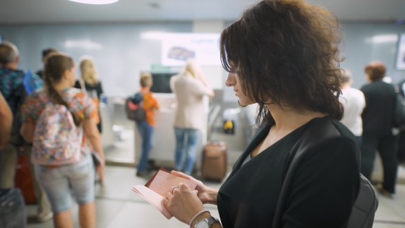 A Beautiful Lady Is Checking Her Passport Before The Trip alt