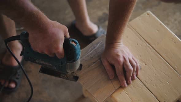 A Worker Installs a Laminate Floor During Finishing Work  Cutting with an Electric Jigsaw  Carpentry