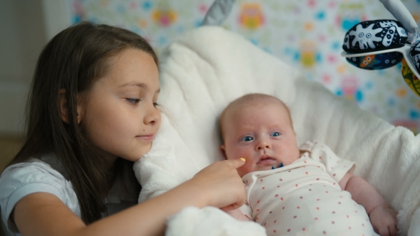 The Little Girl Looks At Her Baby Sister alt
