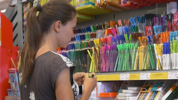 Girl Chooses Among Different Colors Of Highliters