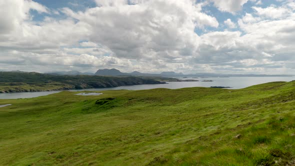 A wide panning landscape view of the mountains (suilven) and rocky coastline of North Scotland (Suth alt