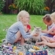 Children Play With a Cat In The Yard. Sitting On a Green Meadow, Stroking The Cat - VideoHive Item for Sale