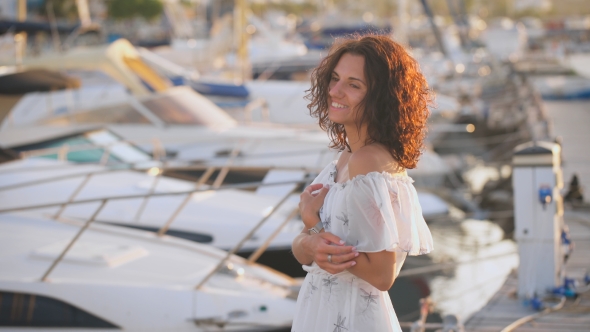 Beautiful Young Woman Smiling On a Pier On a Summer Day alt