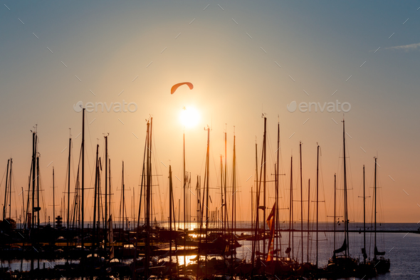 Sunset paragliding over yachts