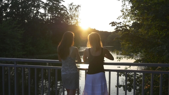 Two Young Women Chatting Outdoor At Sunset