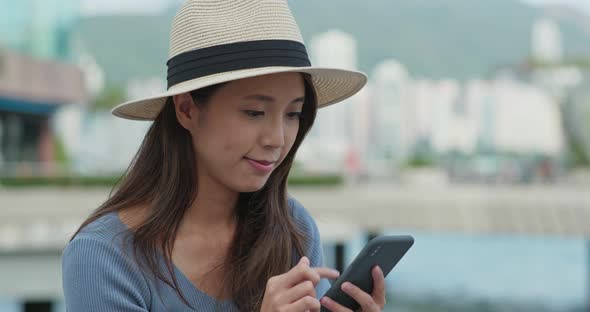 Woman use of mobile phone in city alt