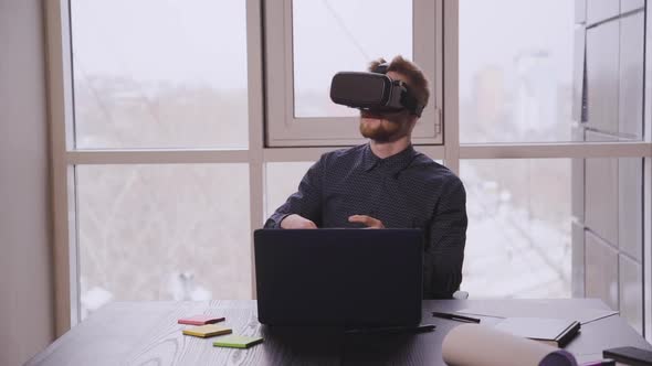 American Businessman Using Vr Glasses Sitting at Table with Laptop in Office.