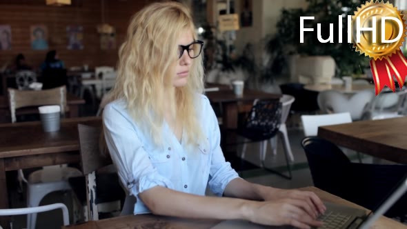 Business Woman Working at a Laptop in a Cafe