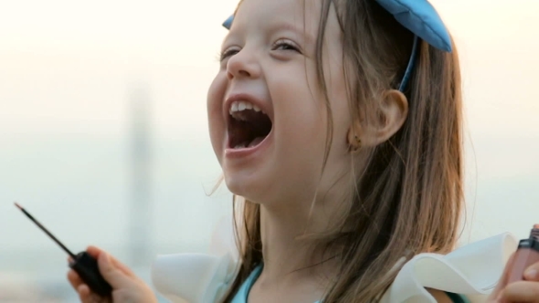 Portrait Of a Little Girl Three Years With The Blue Bow On Her Head, Stands Near The Water