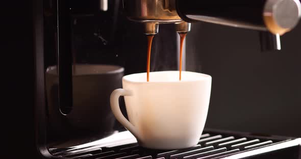 Detail of a professional coffe maker dripping coffe into an empty cup in a cafeteria, alt