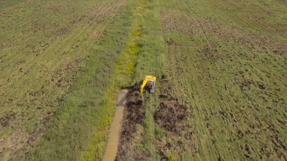 Excavator Digging a Trench In The field.Aerial Video., Stock Footage