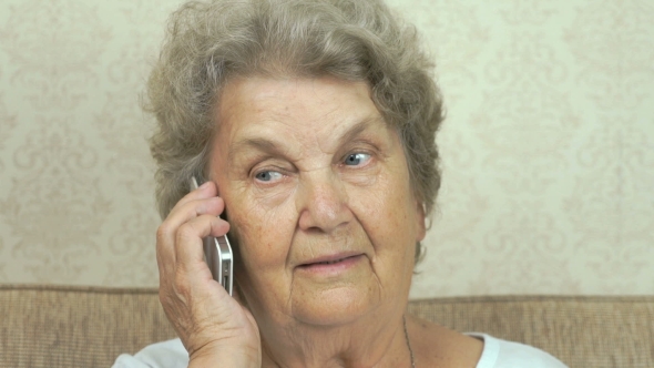 Old Woman Talking Smartphone At Home