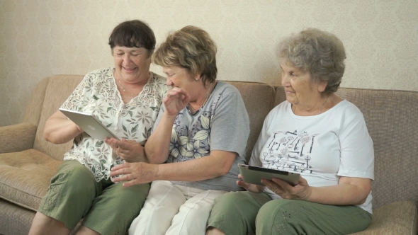 Elderly Women Looking Photos Using Digital Tablets