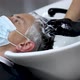 Female hairdresser hands in rubber gloves washes the head of a medical mask man. A hairdresser with - VideoHive Item for Sale