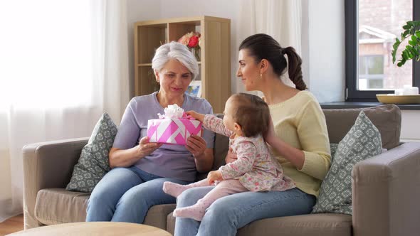 Mother and Daughter Giving Grandmother Present alt